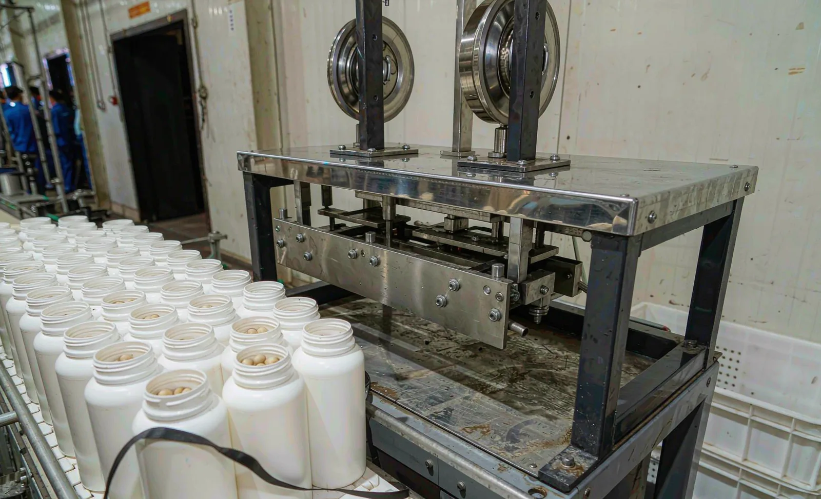 Automatic bottling and labeling line packaging supplement capsules into opaque bottles