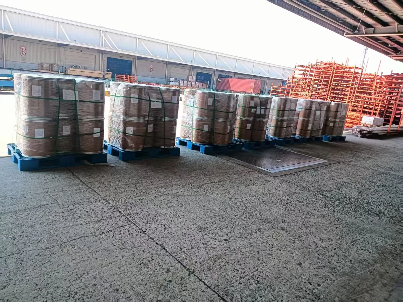 Palletized ingredient drums lined up at a warehouse dock